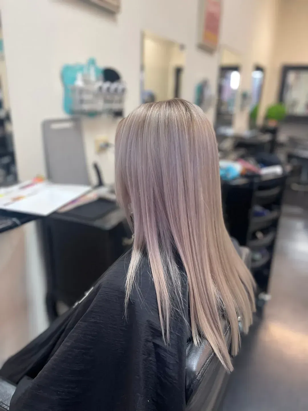 A Woman With Long Red Hair is Sitting in a Chair in a Salon — Southside Hair & Beauty Design In South Tamworth, NSW
