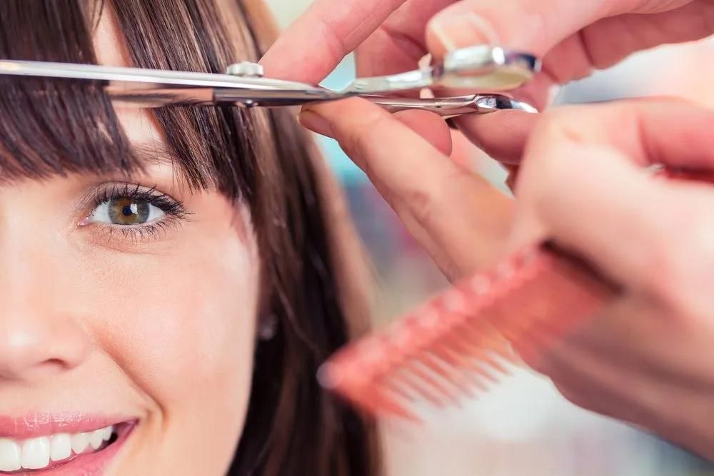 A Woman is Getting Her Hair Cut by a Hairdresser — Southside Hair & Beauty Design In South Tamworth, NSW A Woman is Getting Her Hair Cut by a Hairdresser — Southside Hair & Beauty Design In South Tamworth, NSW