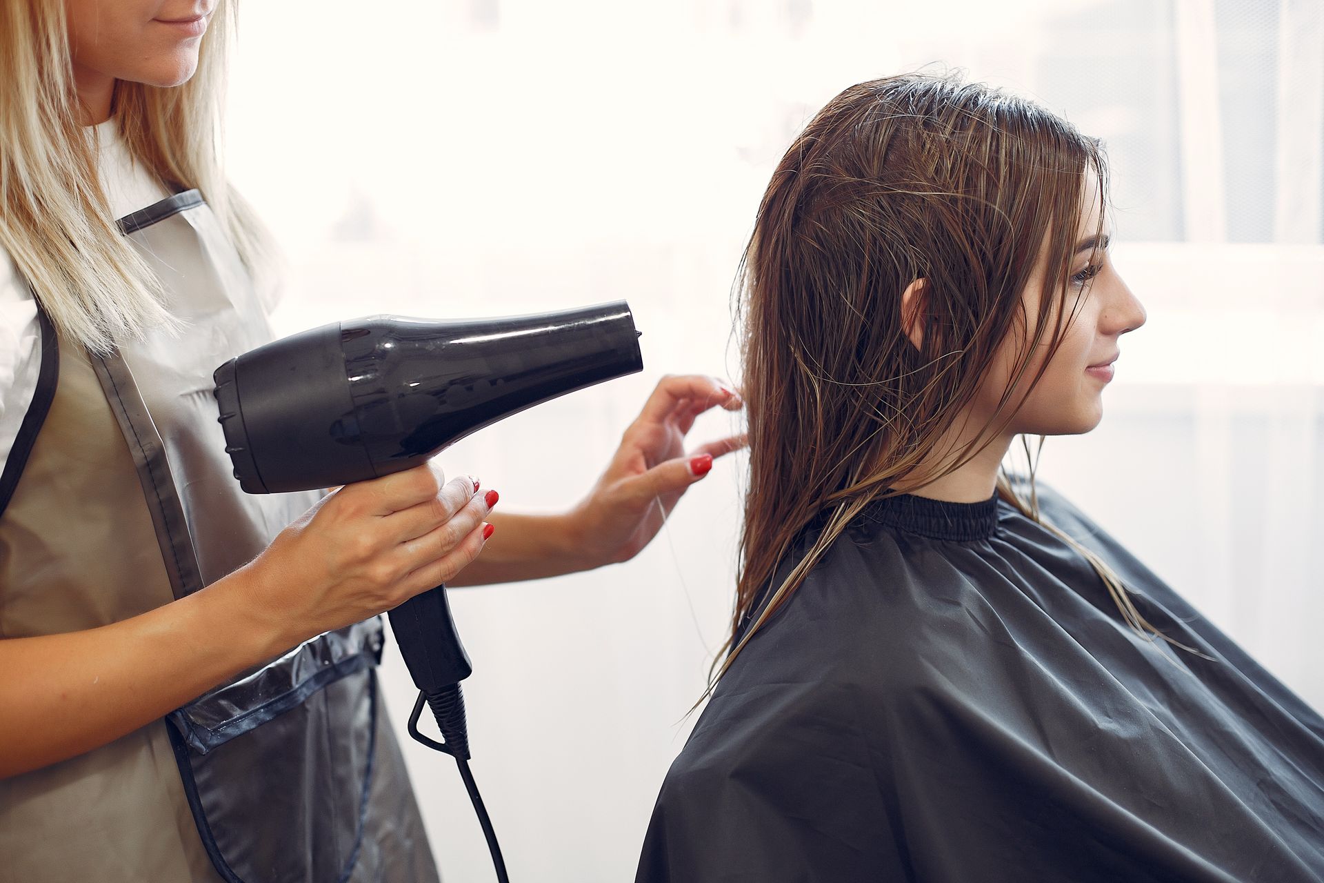 Hair Stylist Blow-dries a Client's Dark Hair in a Salon — Southside Hair & Beauty Design In South Tamworth, NSW