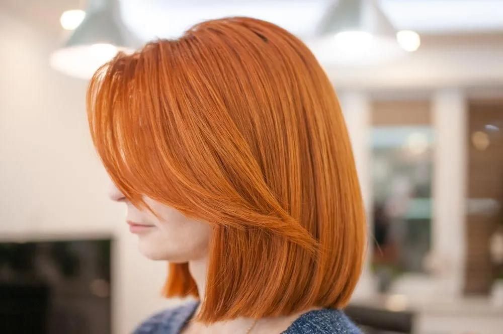 A Woman With Red Hair is Wearing a Blue Sweater — Southside Hair & Beauty Design In South Tamworth, NSW A Woman With Red Hair is Wearing a Blue Sweater — Southside Hair & Beauty Design In South Tamworth, NSW