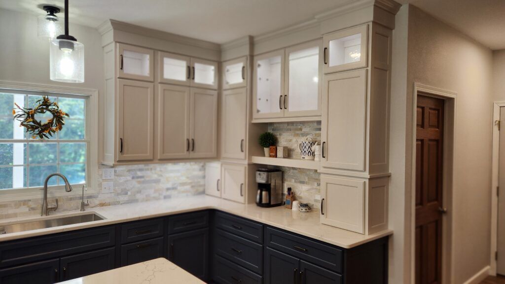 A kitchen with white cabinets and black cabinets and a sink.