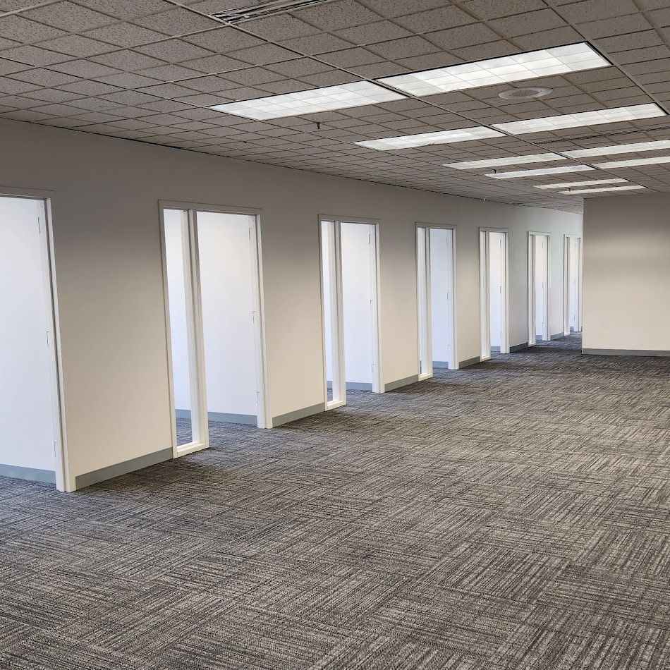 An empty office with a lot of windows and doors.