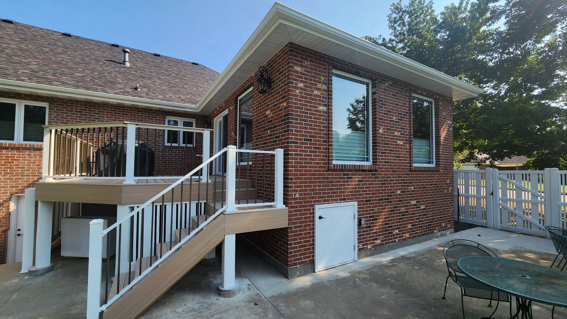 A brick house with a deck and stairs leading up to it