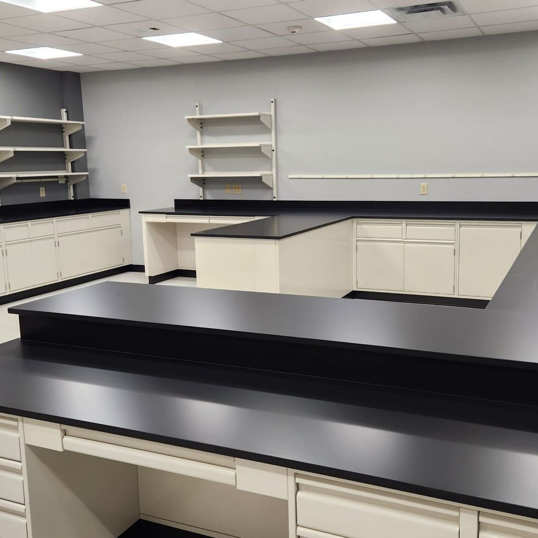A kitchen with black counter tops and white cabinets