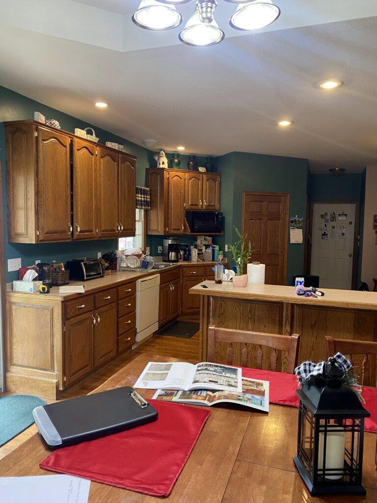 A kitchen with wooden cabinets and a wooden table and chairs.