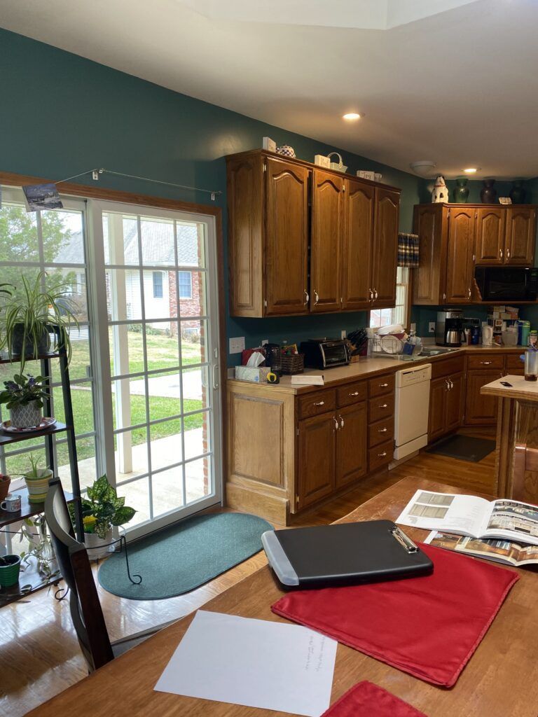 A kitchen with wooden cabinets and a sliding glass door.
