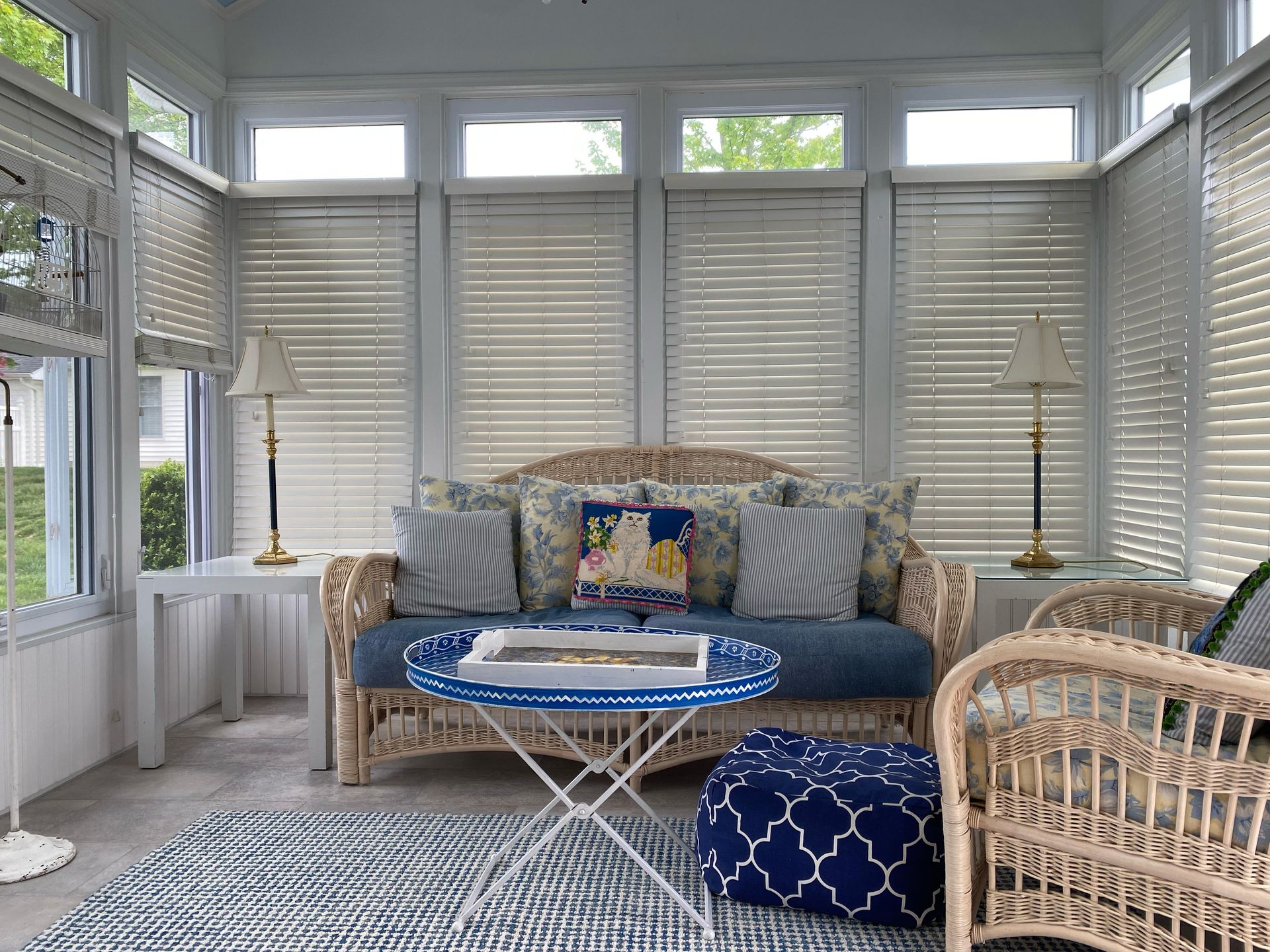 A living room with a couch , chairs , table and blinds.