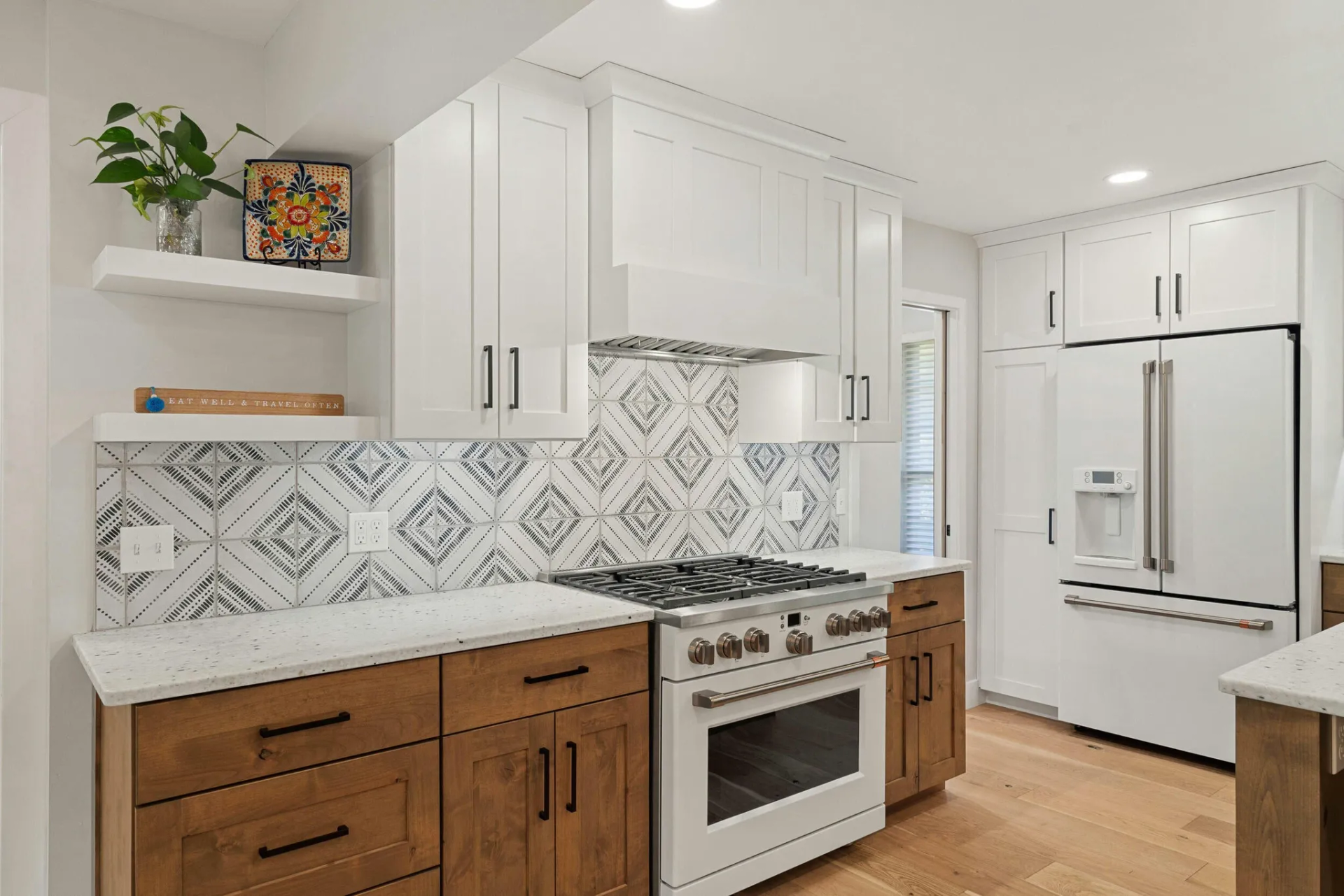 A kitchen with white cabinets , a stove , a refrigerator , and a sink.