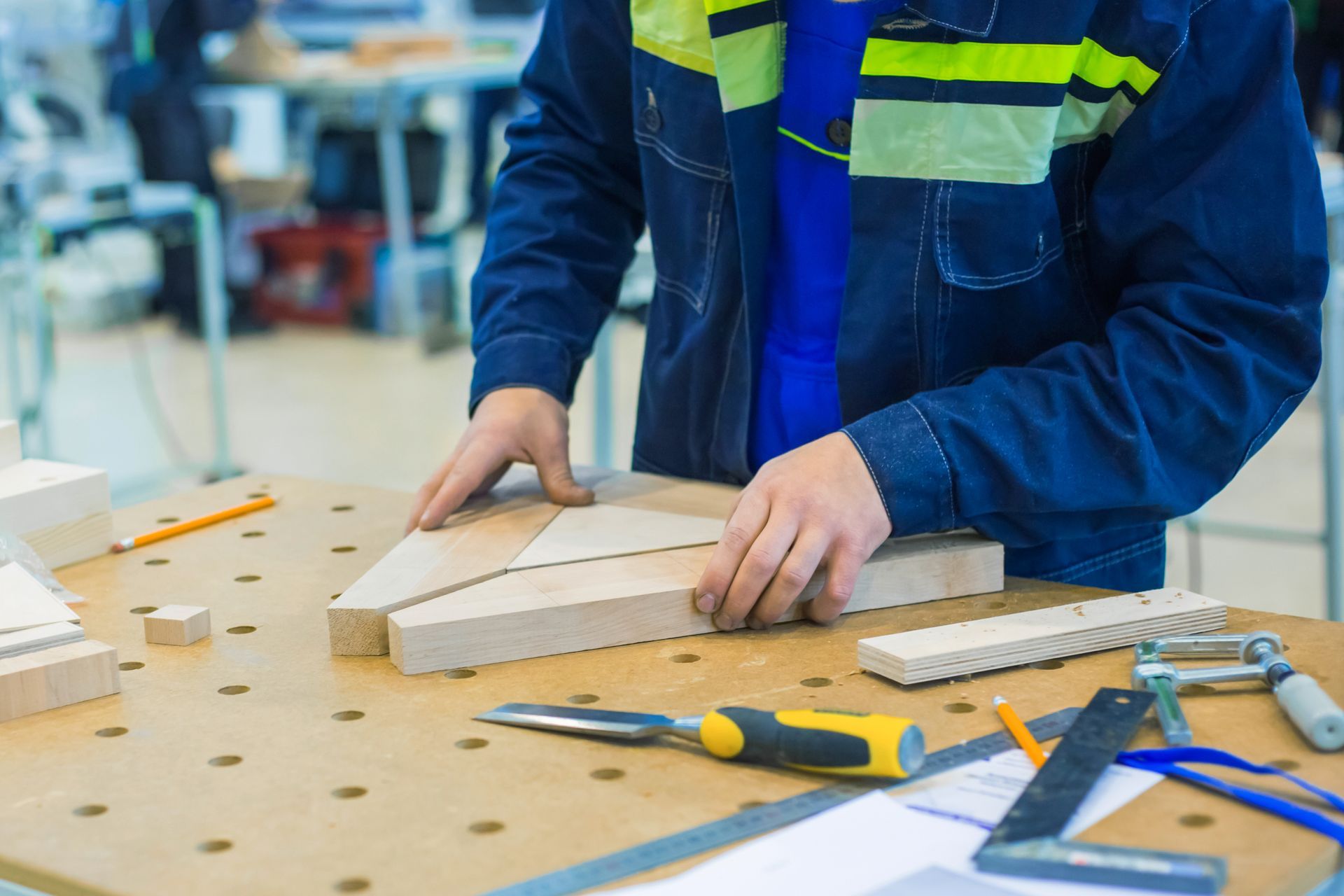 A man is cutting a piece of wood on a table.