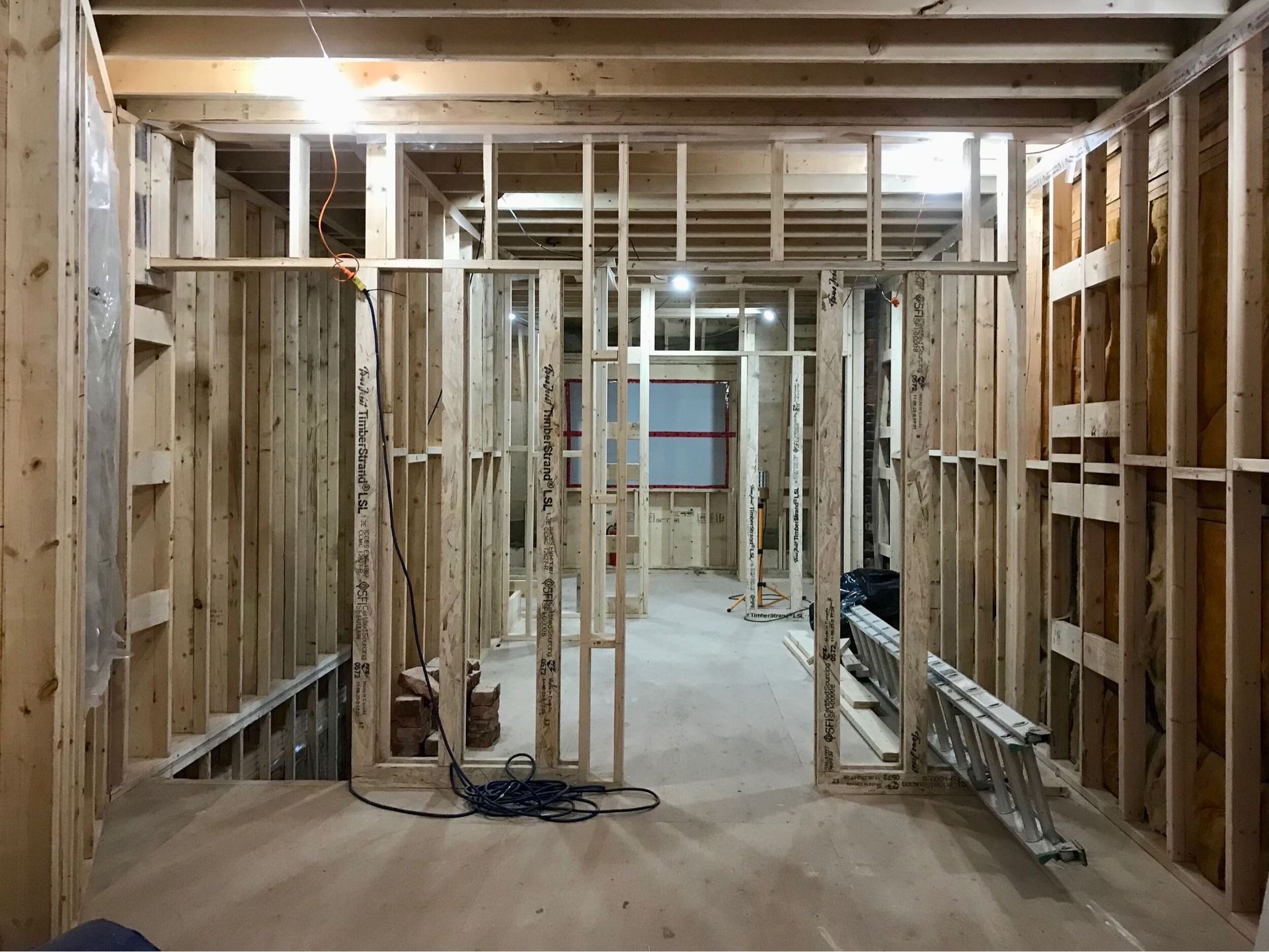 A room with a lot of wooden frames and a ladder on the floor.