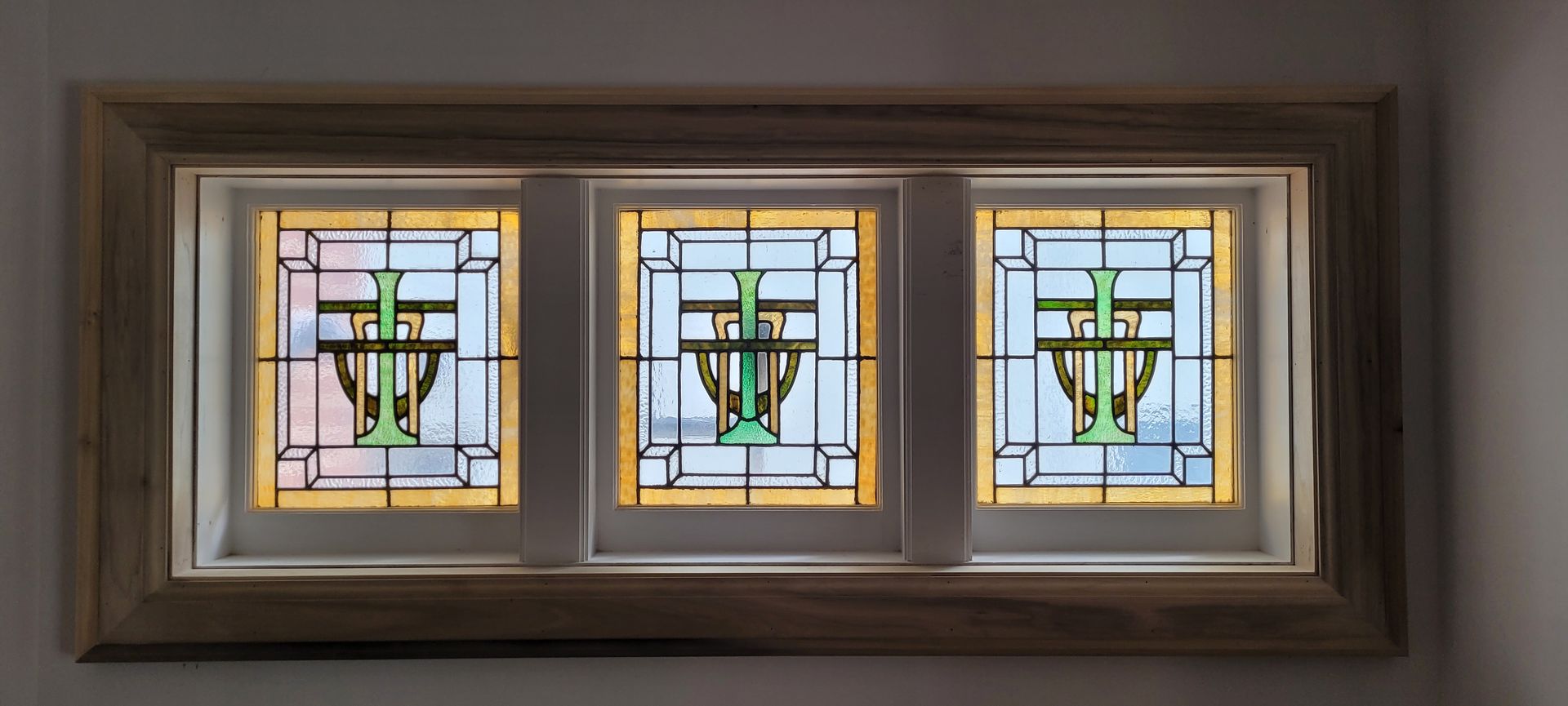 Three stained glass windows with a cross on them