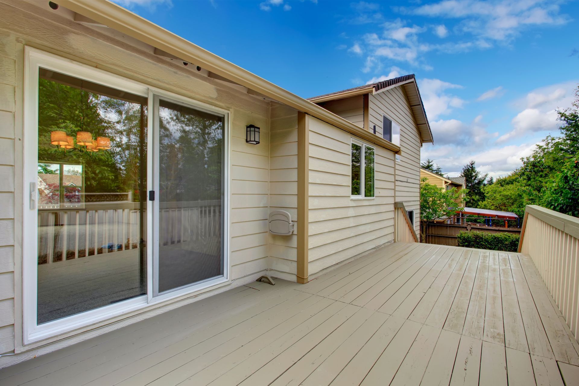 a house with a large deck and sliding glass doors .