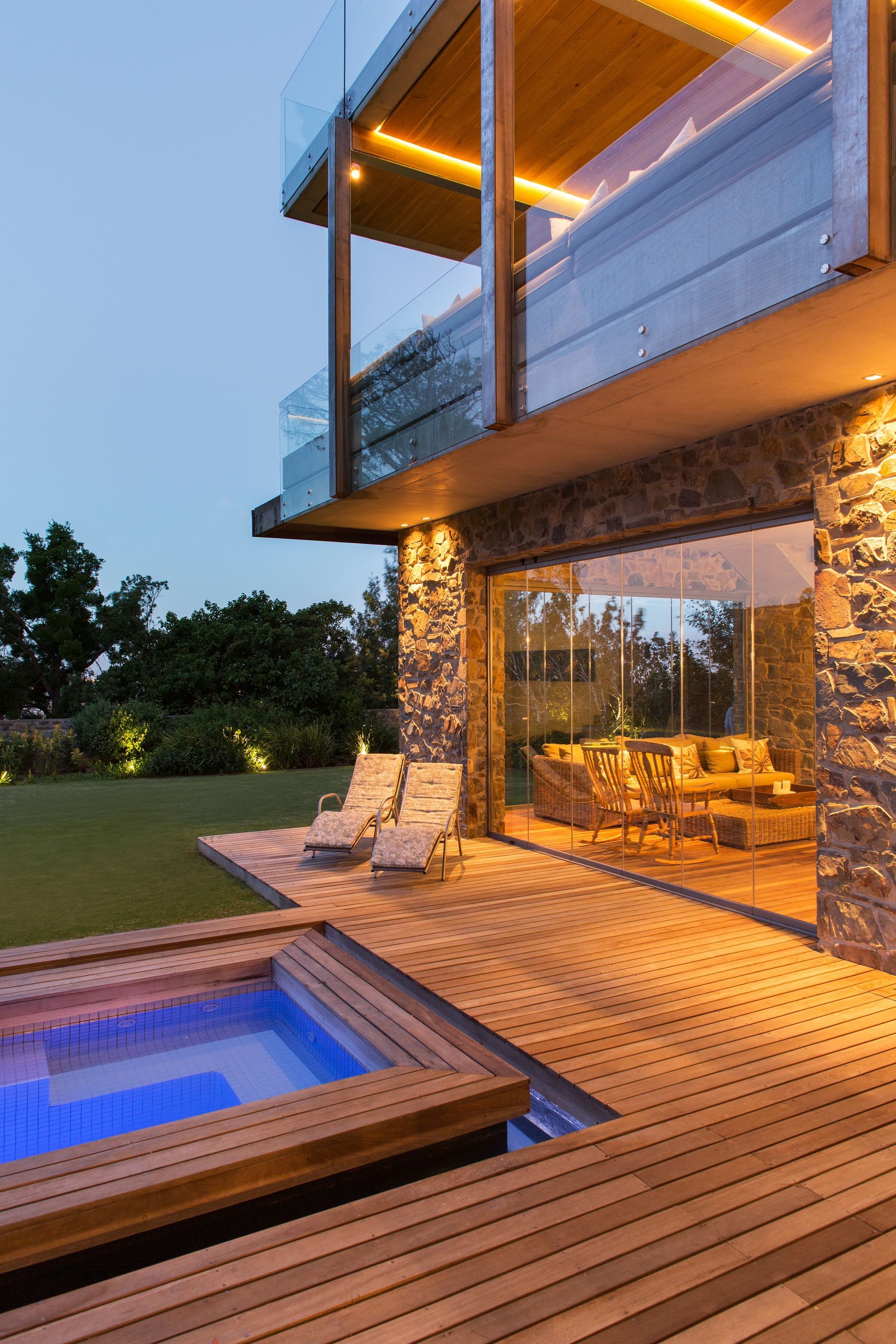 a large house with a swimming pool and a wooden deck .