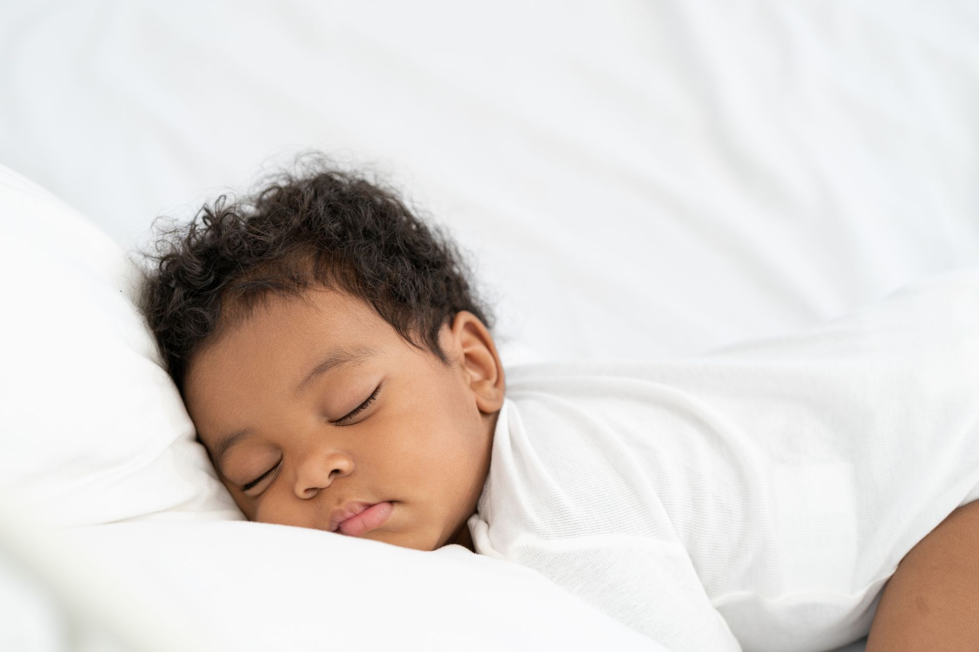 Cute emotional newborn little baby boy sleeping in crib