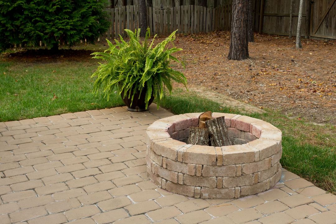 Tradesperson compacting a gravel base for a patio installation