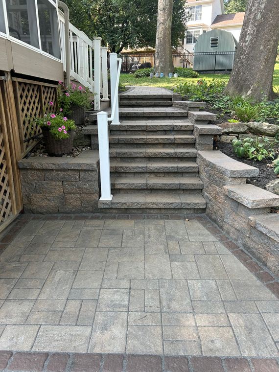 Outdoor wooden deck stairs and ramp beside a house in a grassy yard