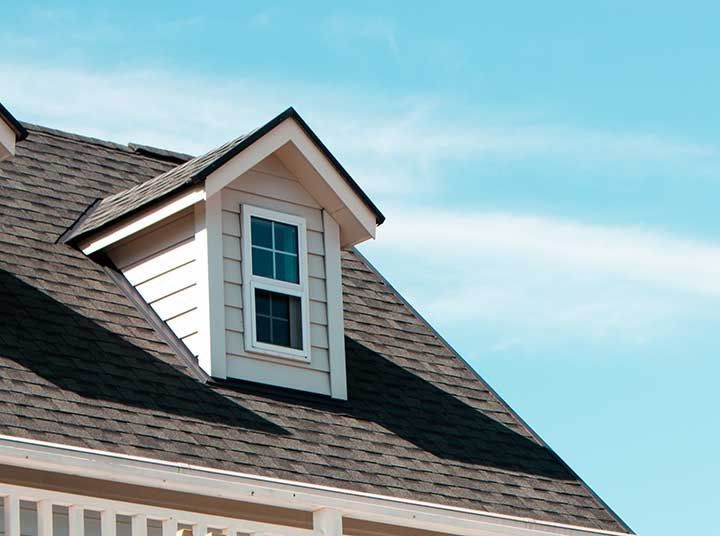 The close up image of authentic  house roof and roof window in blue sky with cloud.
