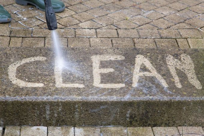 Pressure washer cleaning the word