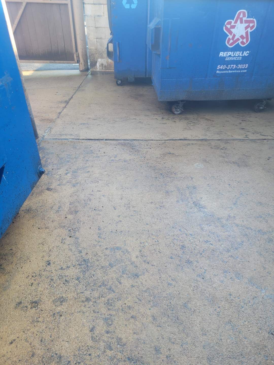 Wet concrete pouring from a truck chute onto a construction site, forming a gravelly slab surface
