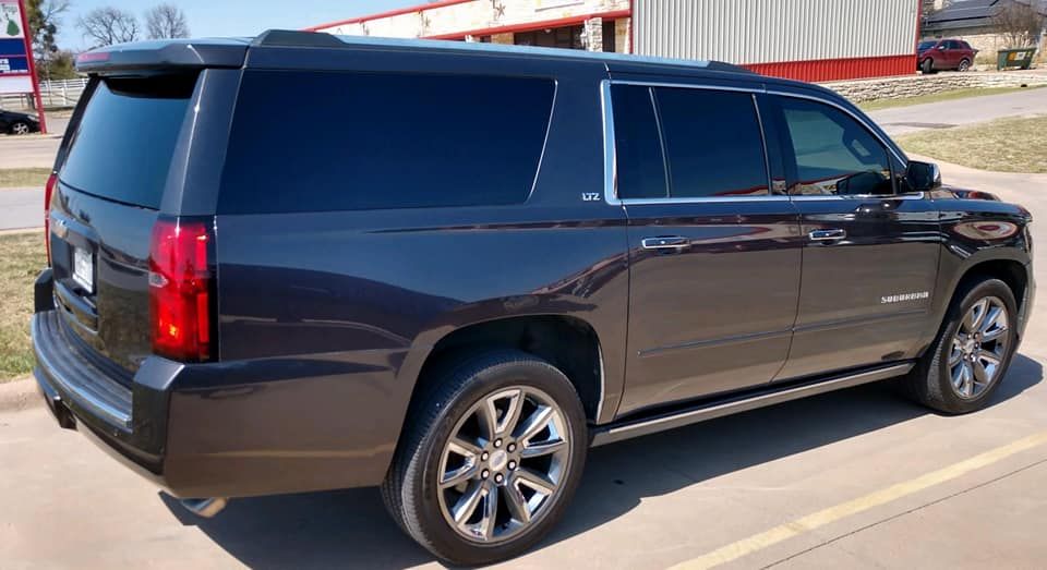 Dark gray SUV parked outside on a sunny day.