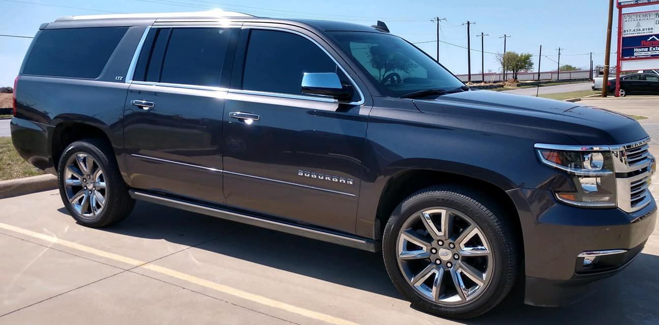 Dark gray Chevrolet Suburban parked on a sunny day.