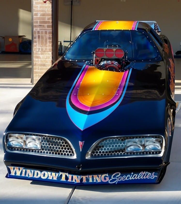 Black drag racing car with colorful airbrushed hood, 