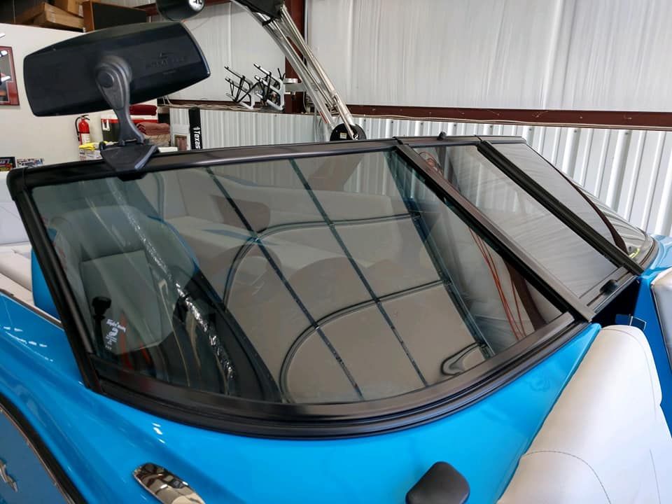 Blue boat windshield with black trim; two sections are open.