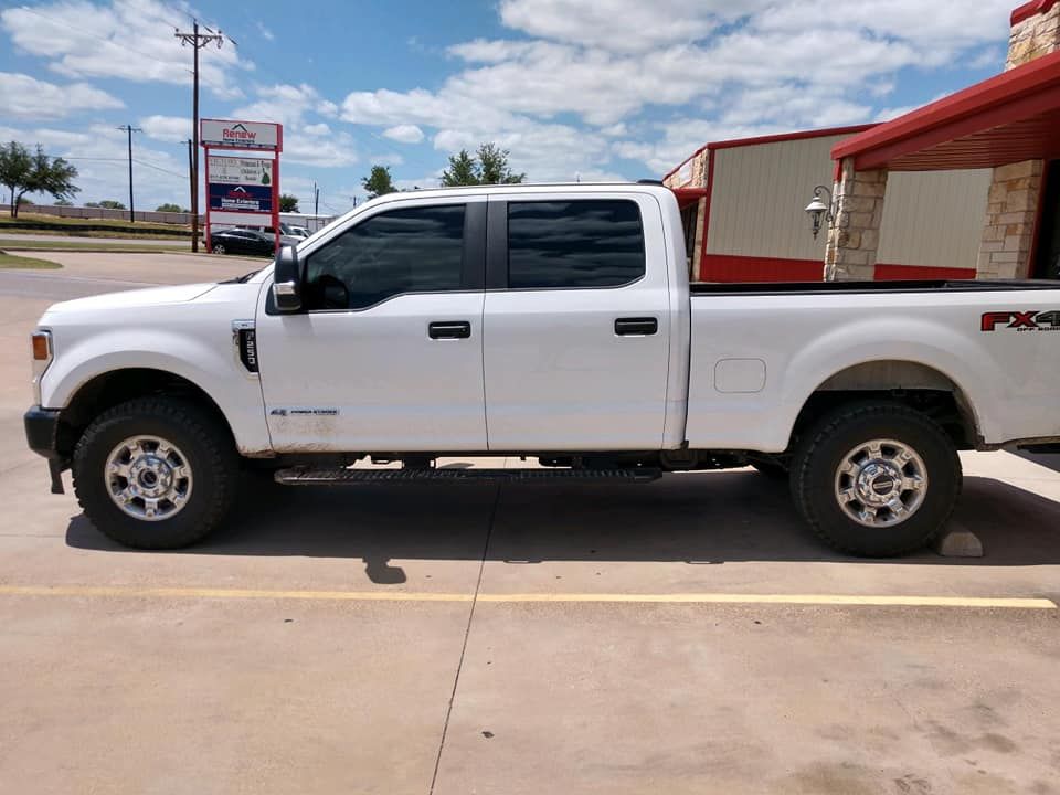 White Ford pickup truck parked in a parking lot on a sunny day.