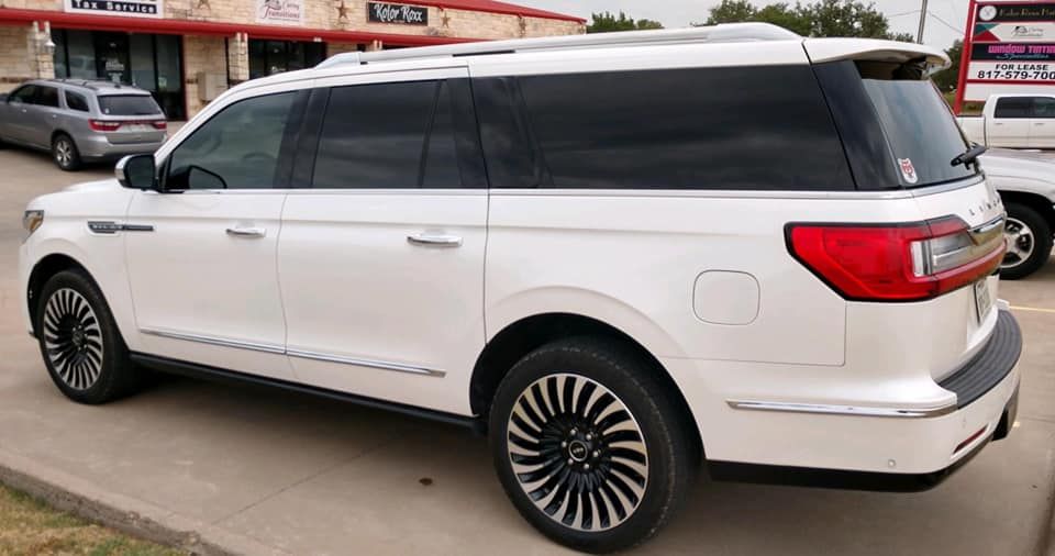 White Lincoln Navigator SUV parked outside a building.
