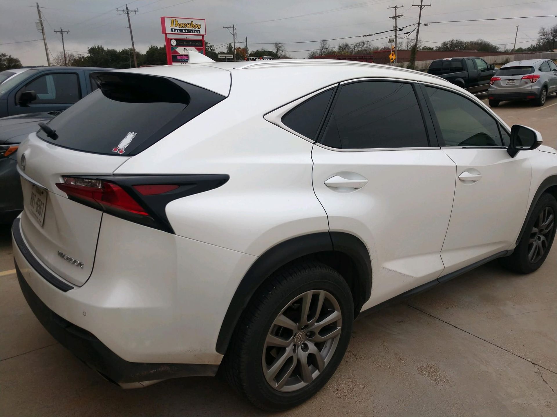 White Lexus SUV parked outdoors on an overcast day.