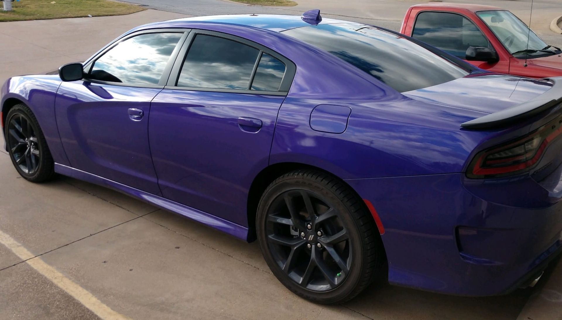 Purple Dodge Charger with black rims parked outside.