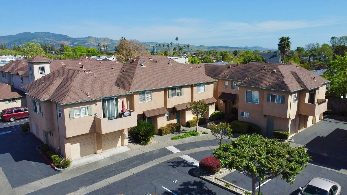 An aerial view of a residential area with a golf course in the background.