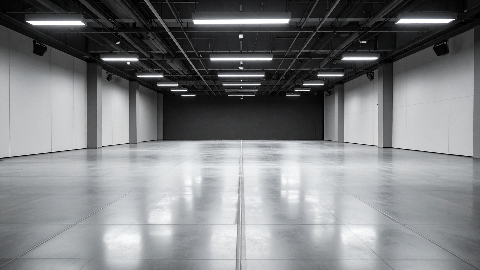 Empty modern warehouse with polished concrete floor and overhead strip lighting