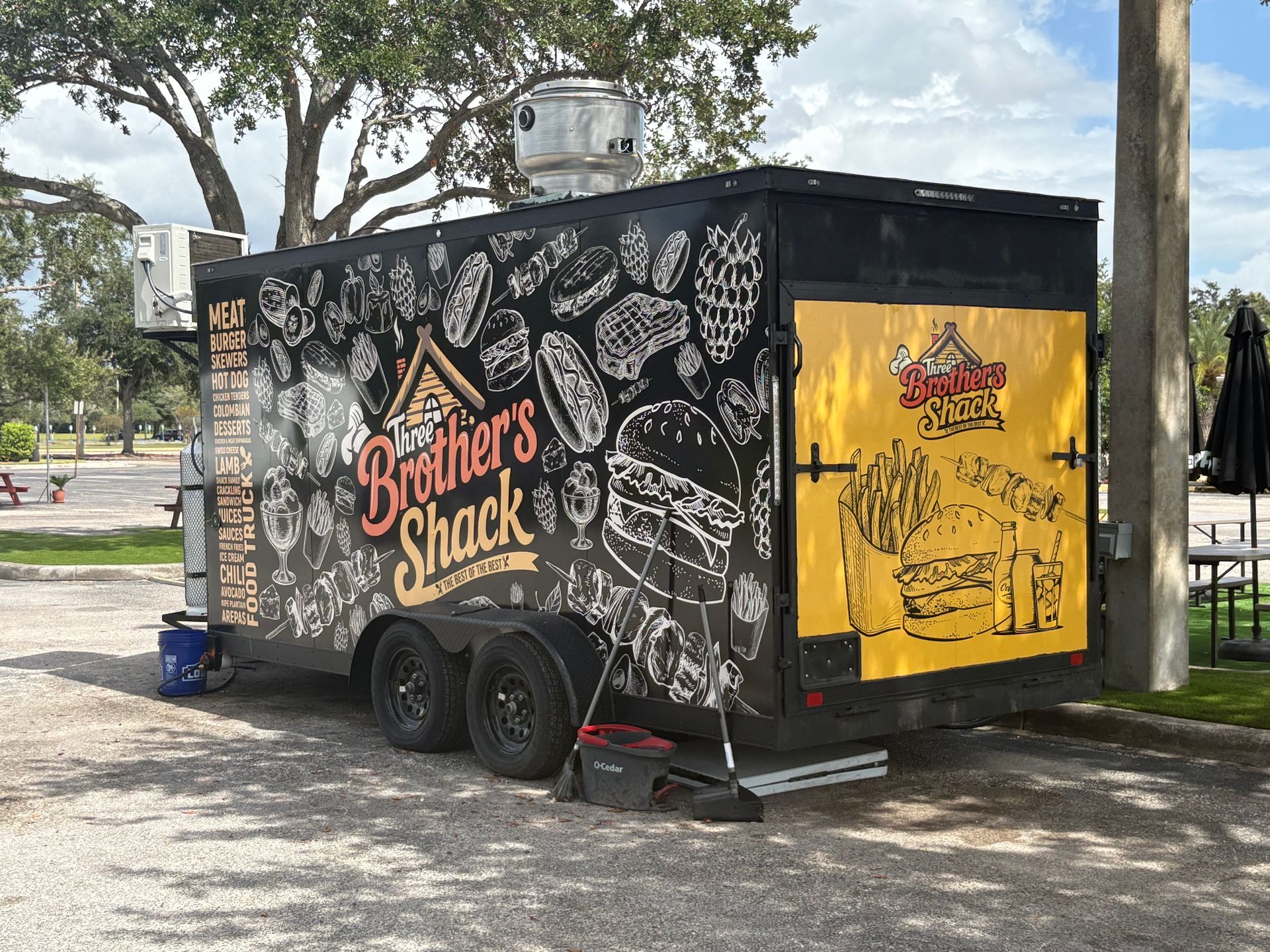 Man examines a large printed graphic rolling out of a wide-format printer in a print shop.