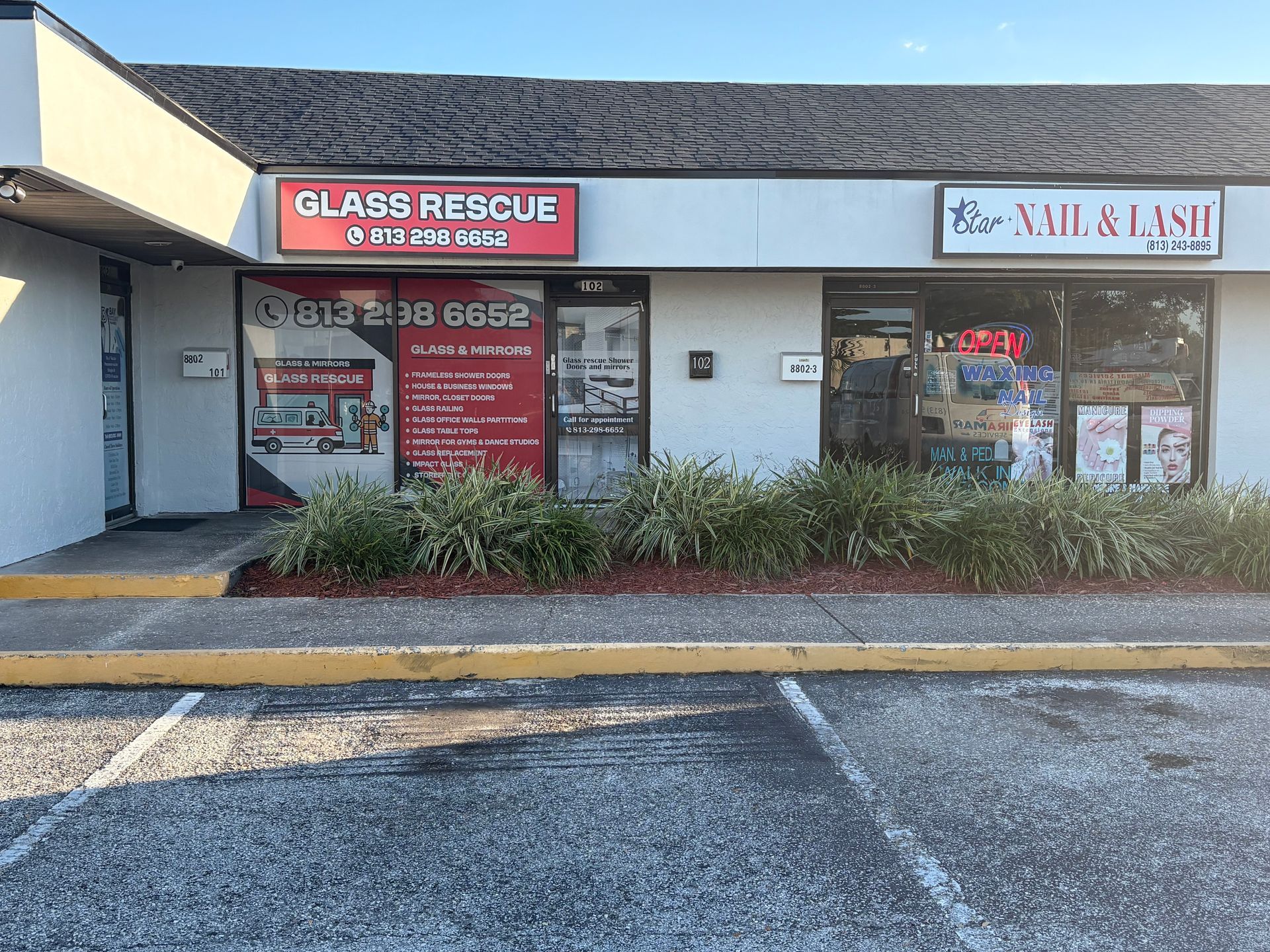 Storefronts for Glass Rescue and Nail & Lash in a strip mall with parking spaces in front