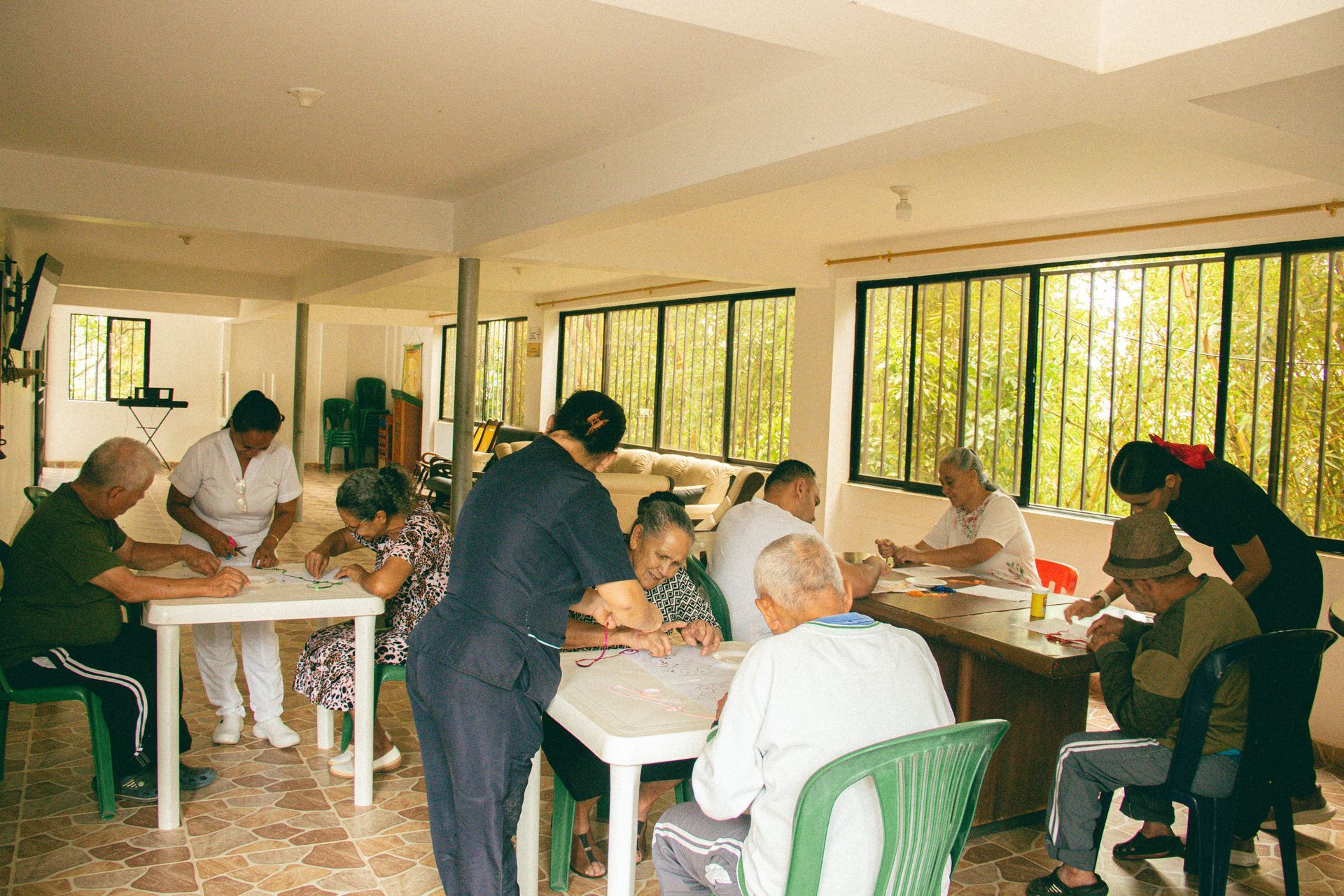 En una sala luminosa, la gente estaba sentada en mesas, comiendo y charlando cerca de grandes ventanales.