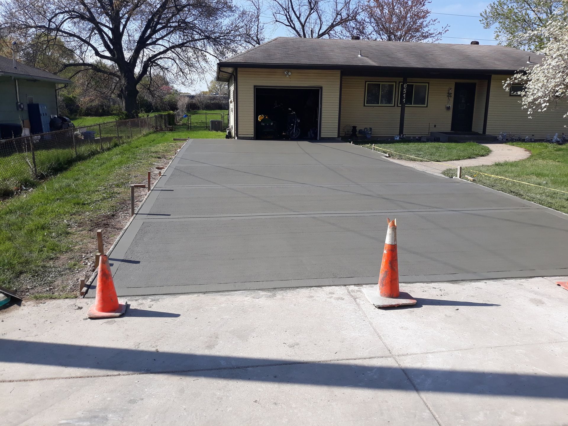 A concrete driveway is being built in front of a house.