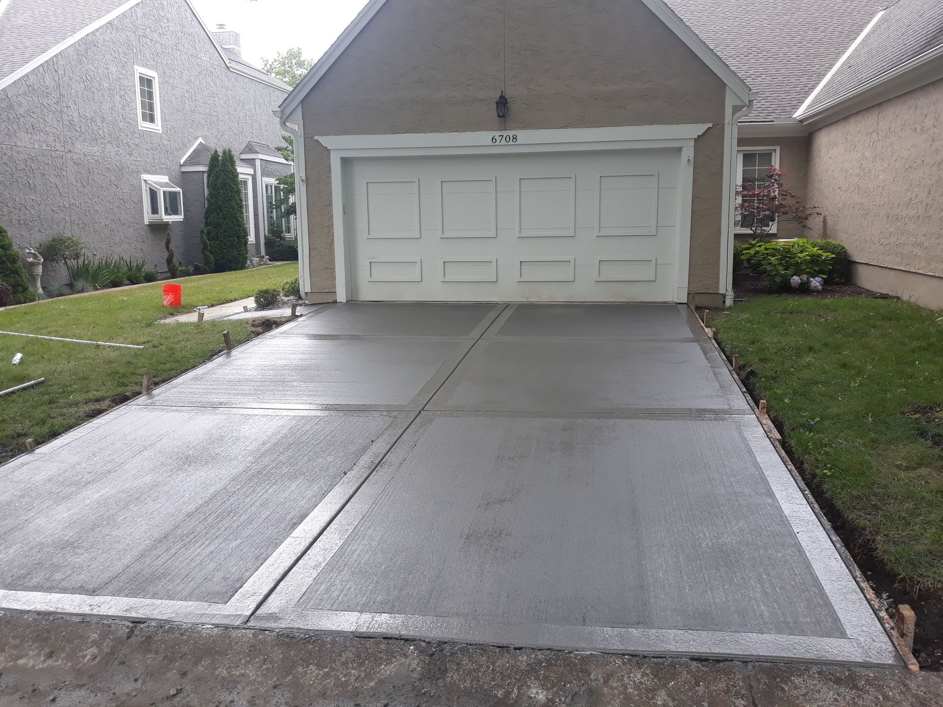 A concrete driveway in front of a house with a garage door