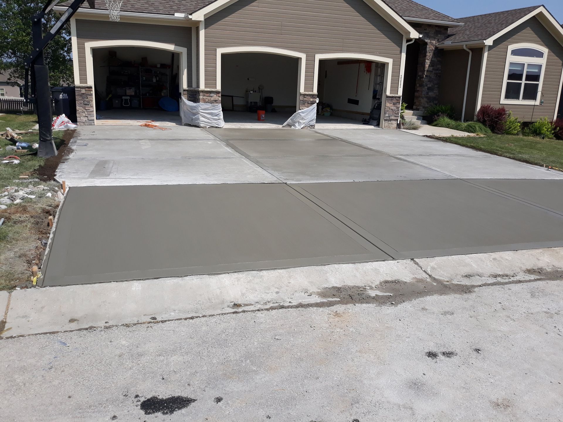 A concrete driveway is being built in front of a house.