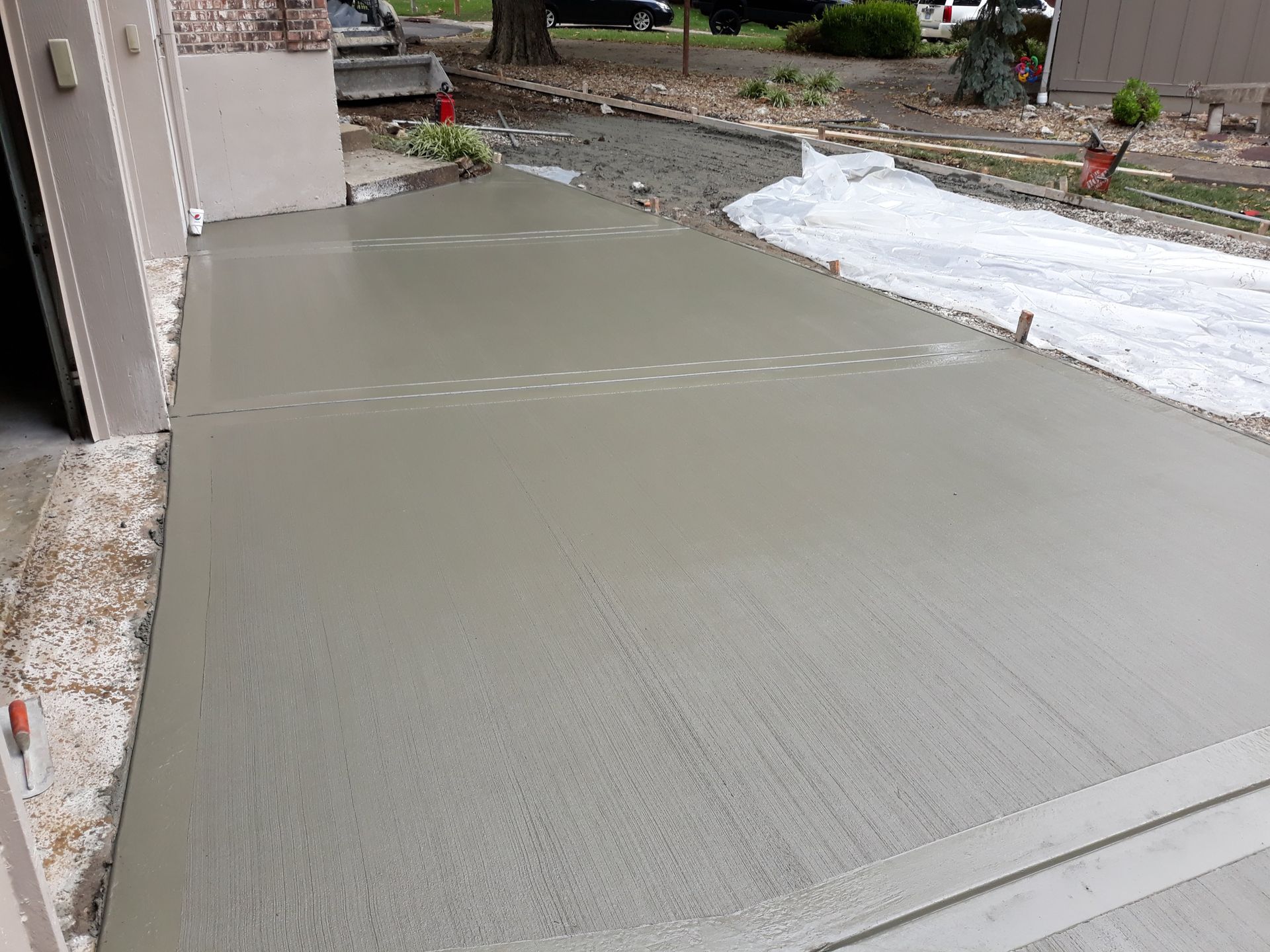 A concrete driveway is being built in front of a house.