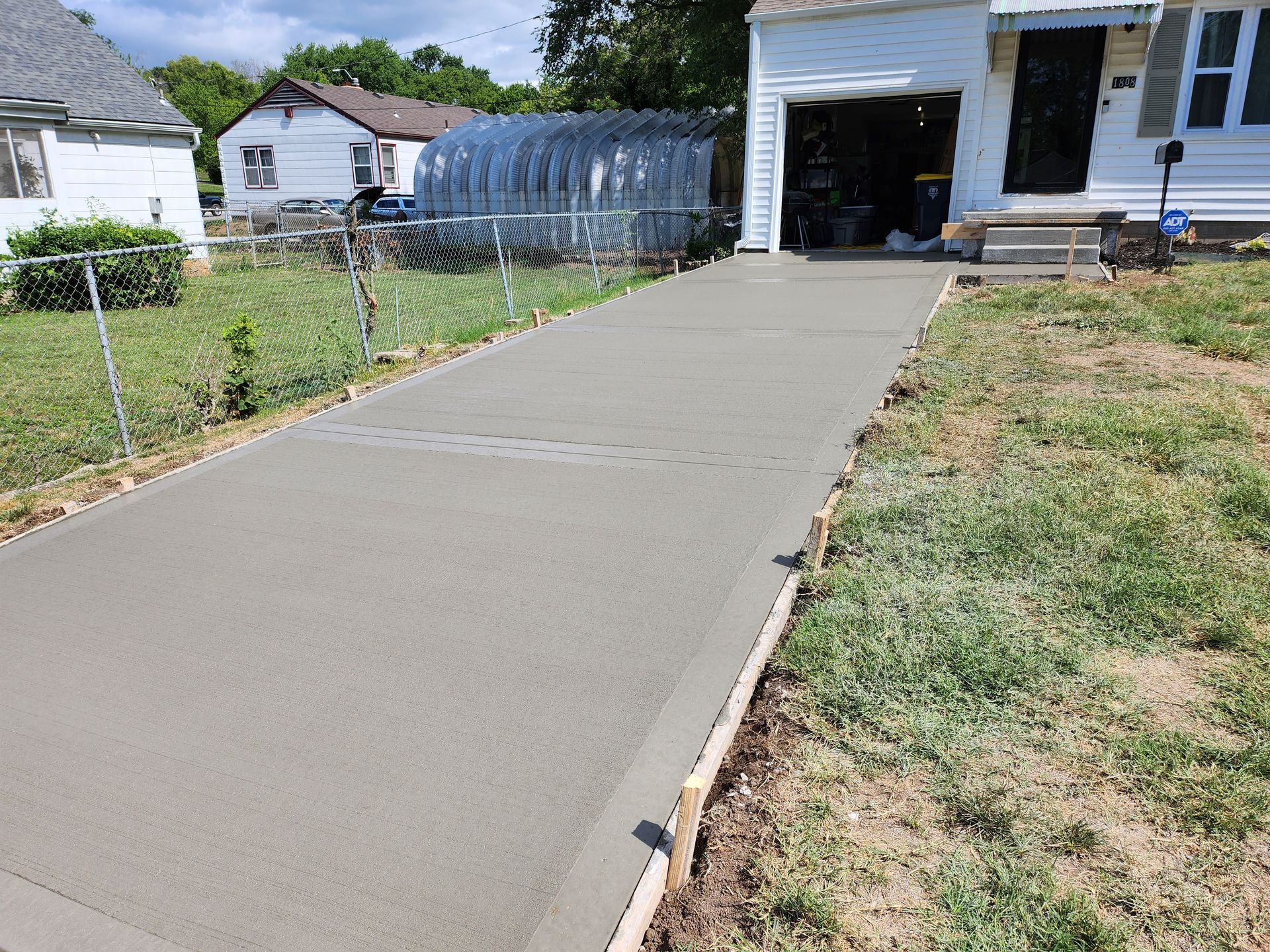 A concrete driveway is being built in front of a house.