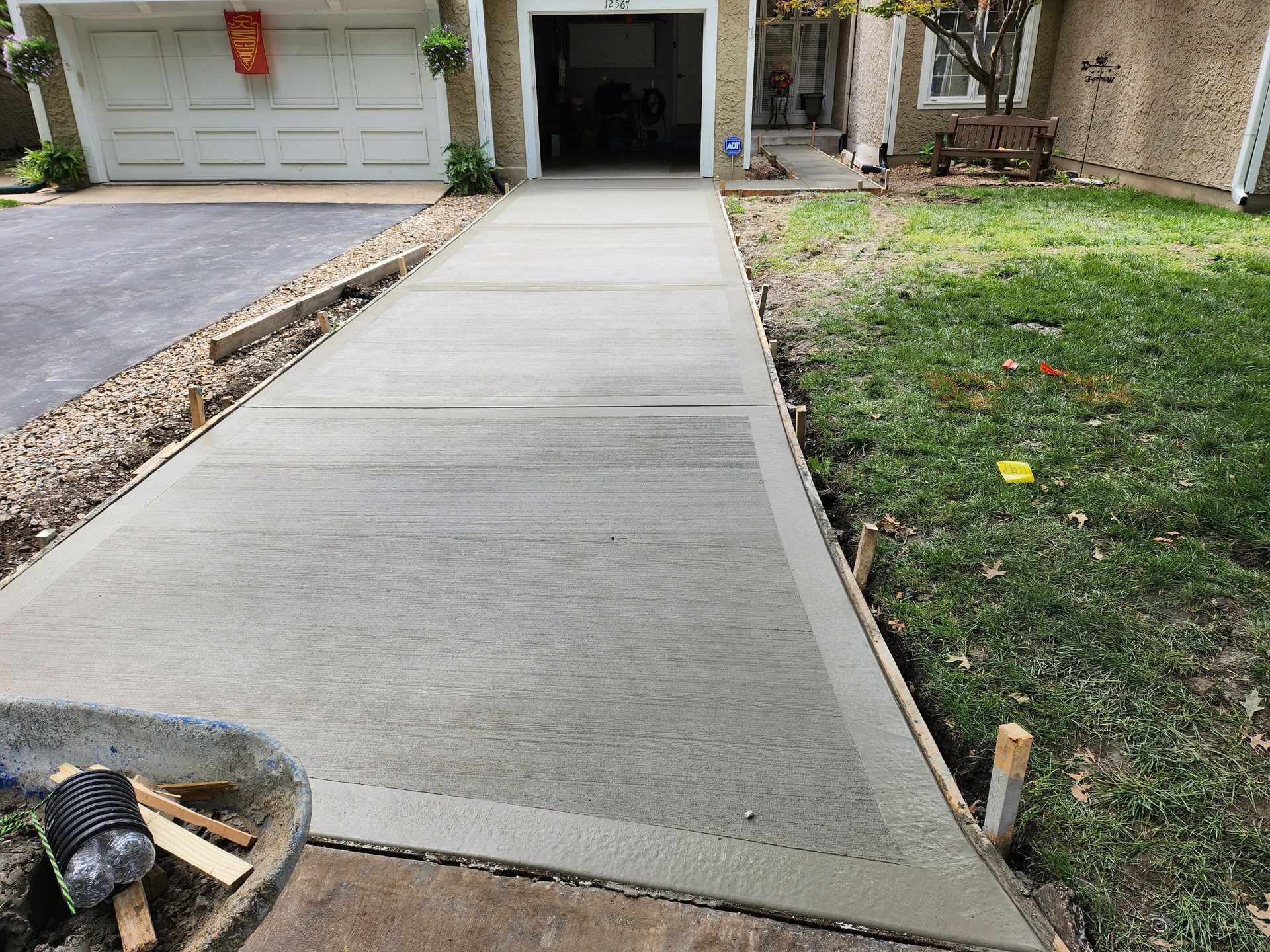 A concrete driveway is being built in front of a house.