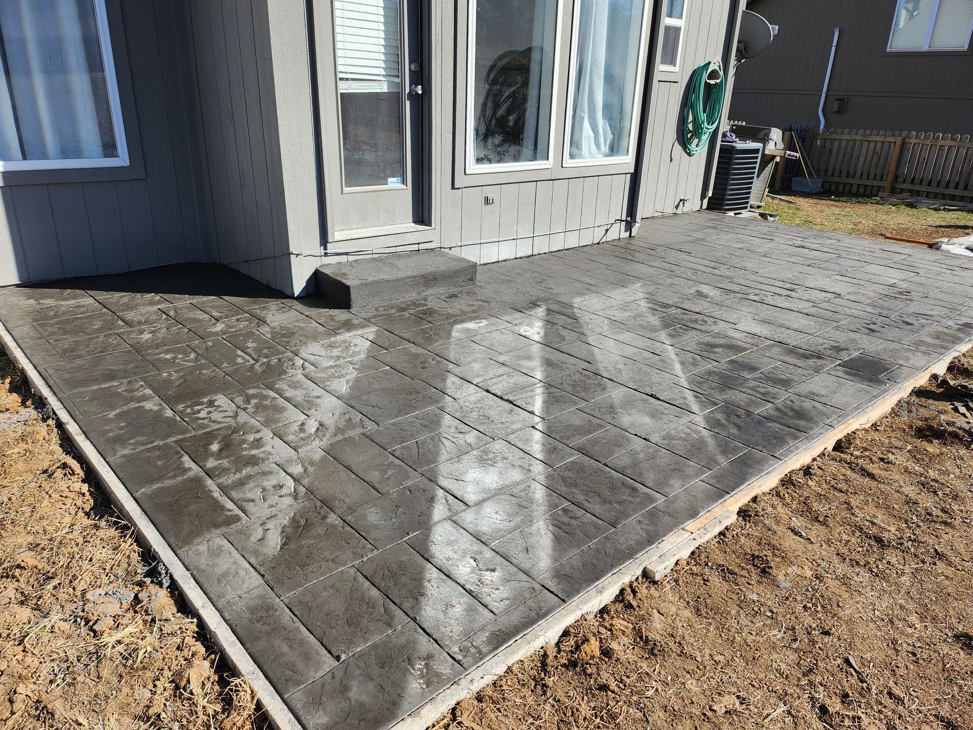 A patio is being built in front of a house.