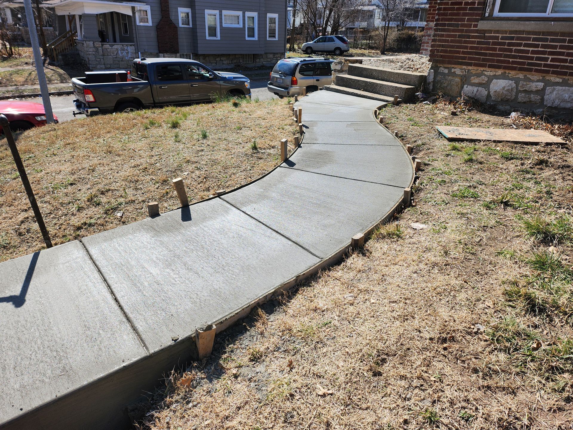 a concrete sidewalk is being built in front of a house