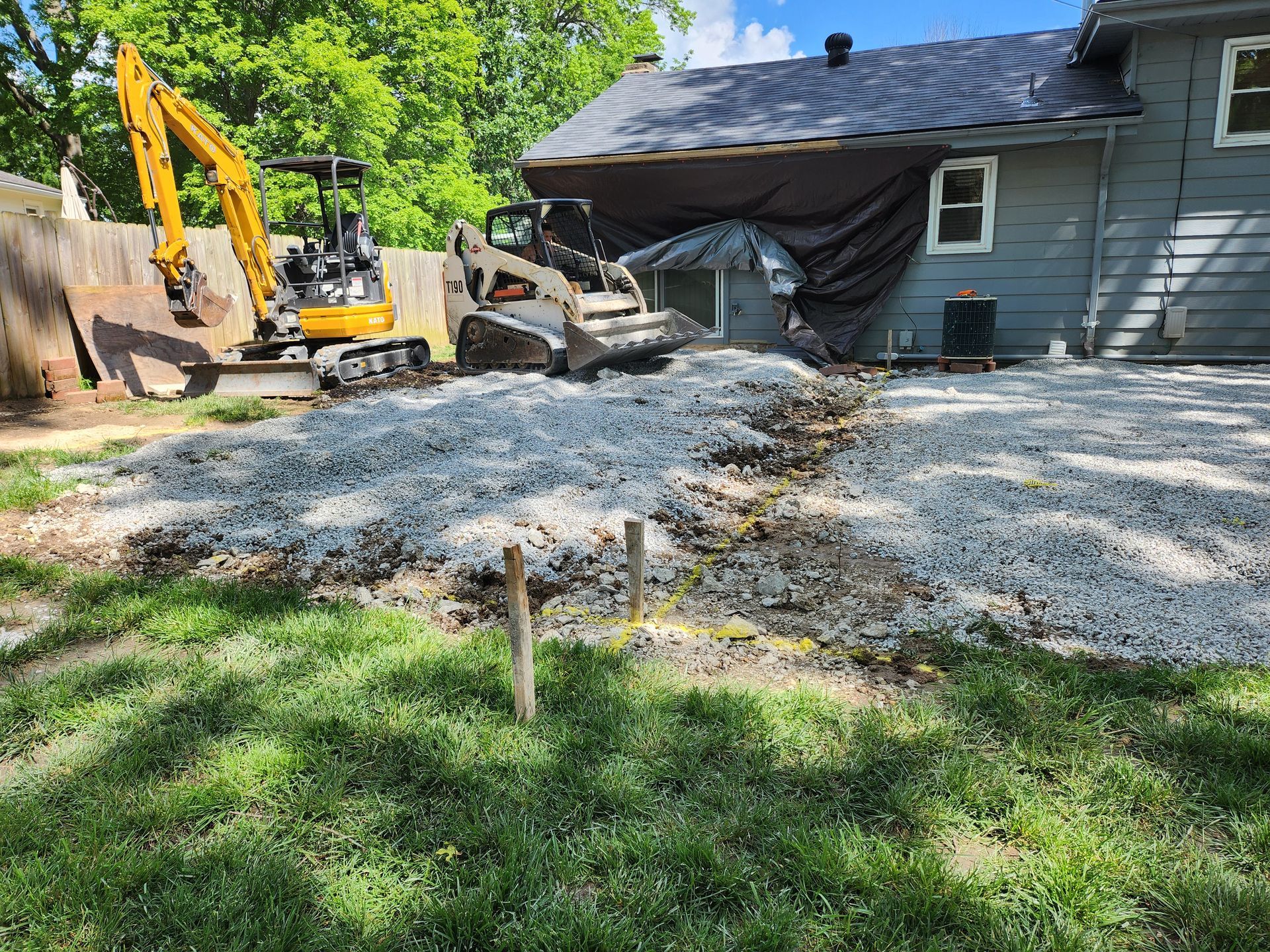 A patio is being prepared for in the backyard of a house