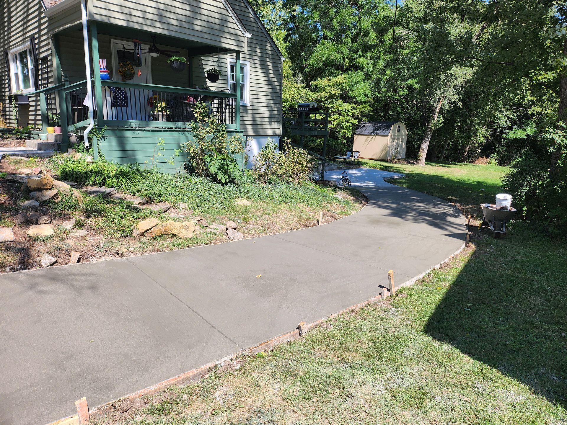 A concrete walkway is being built in front of a house.