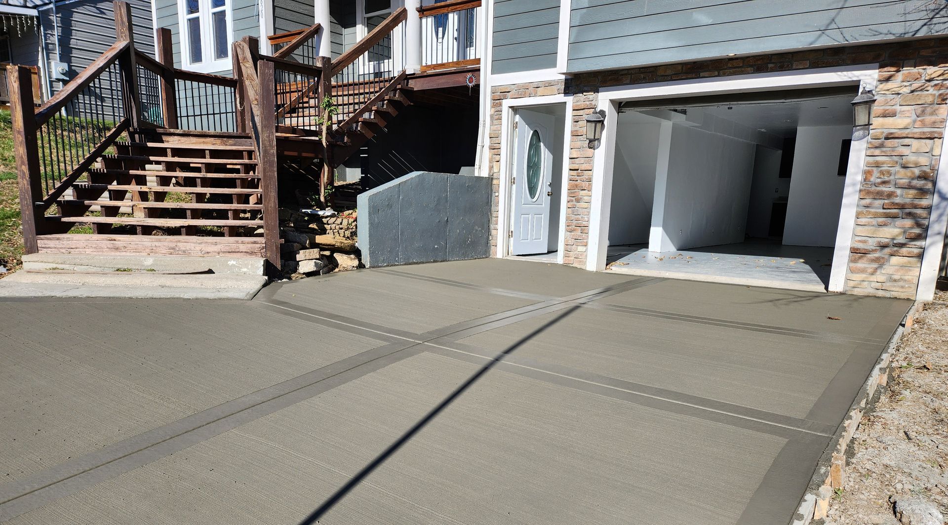 A concrete driveway is being built in front of a house.