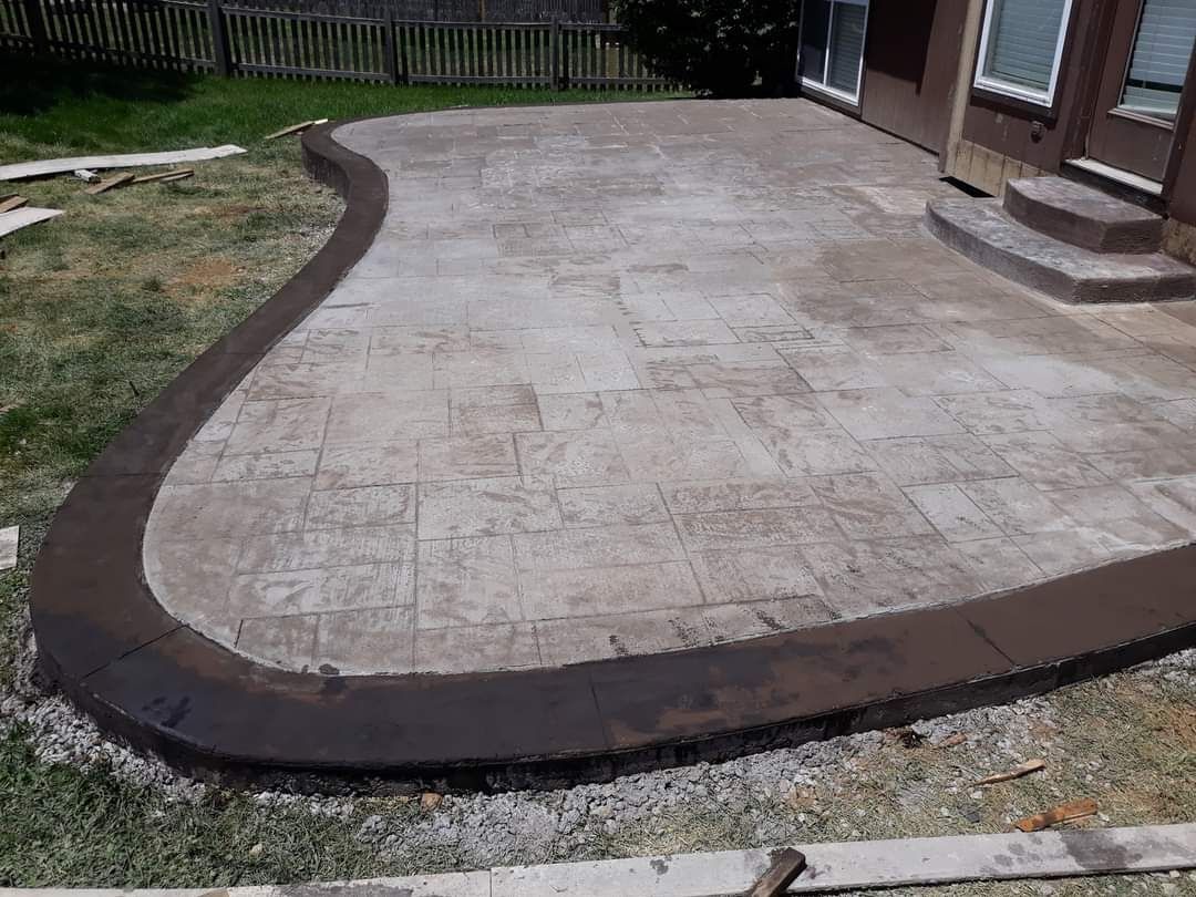 A concrete patio is being built in front of a house.