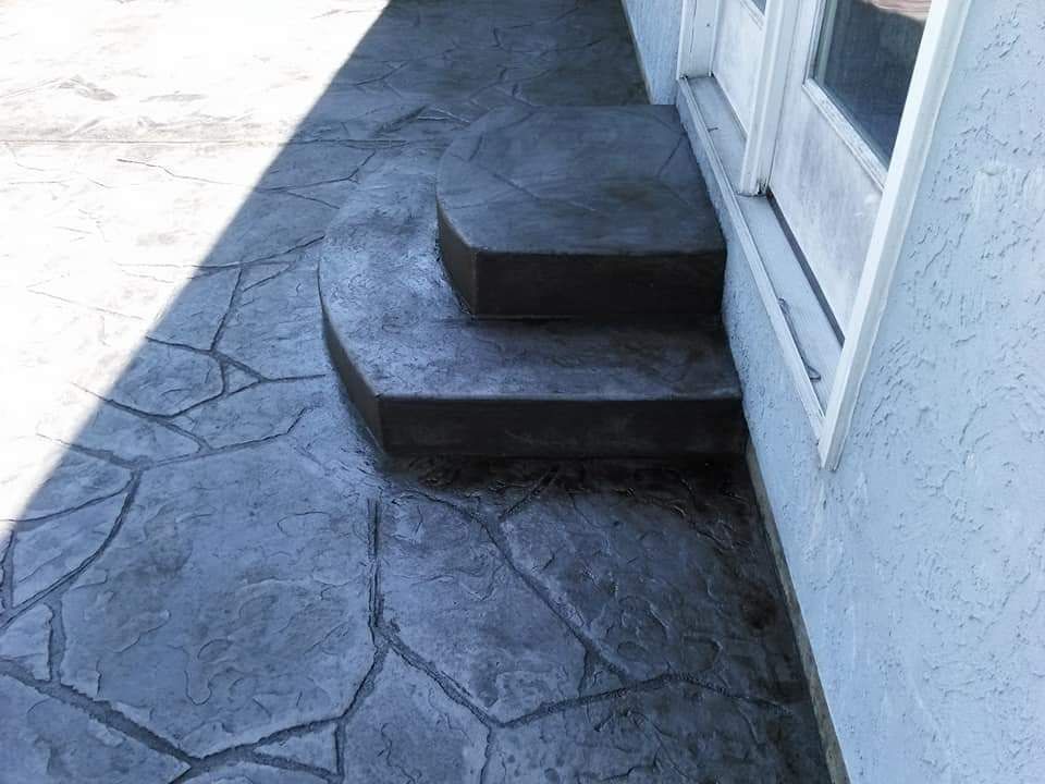 A concrete walkway with steps leading up to a door.