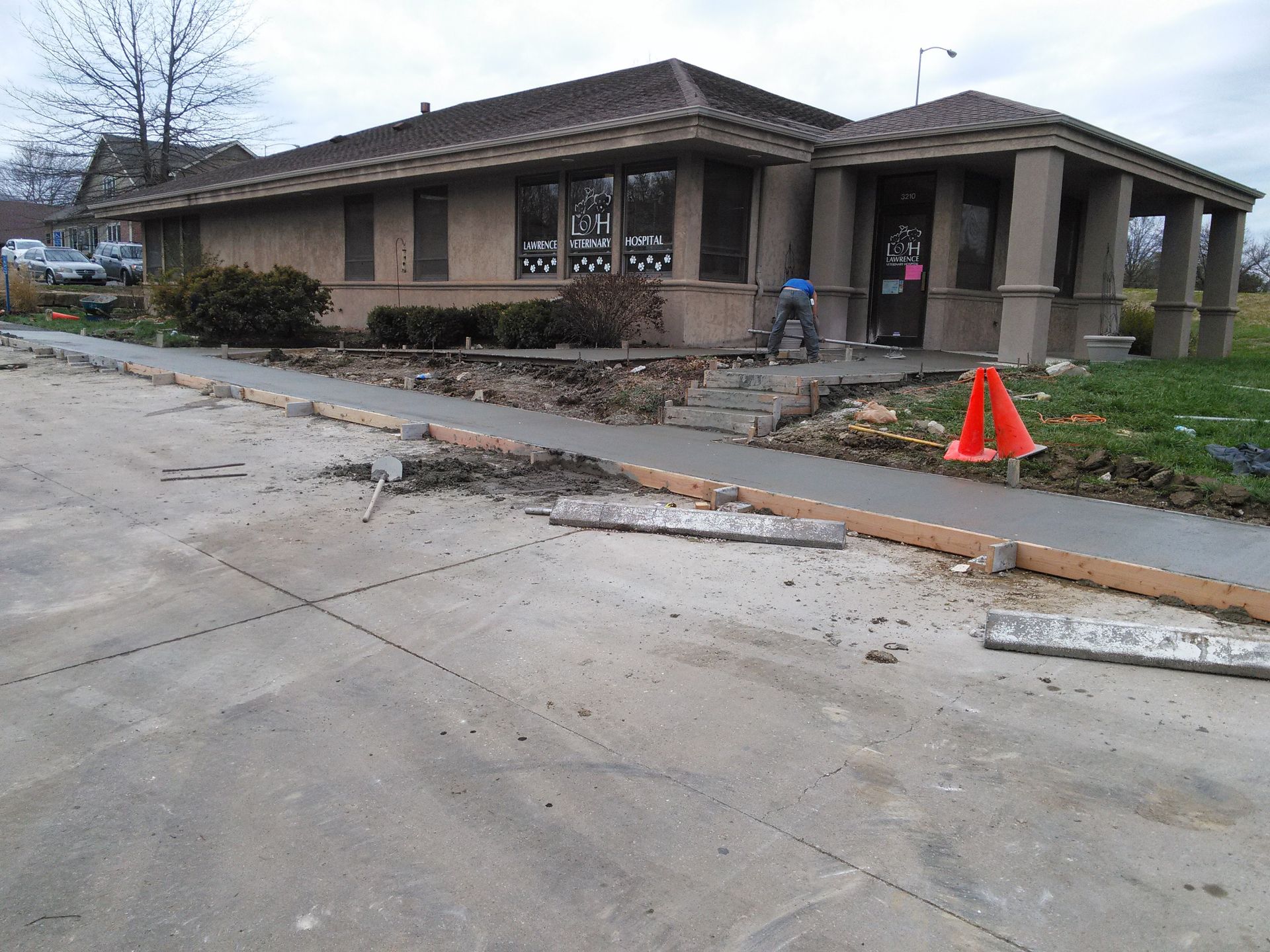 A concrete walkway is being built in front of a building